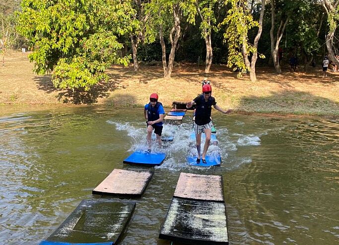  Pupils walking on a floating platform, exploring balance and courage through outdoor challenges at Brighton College Vibhavadi. 