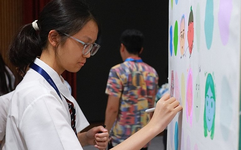  Pupils proudly presenting their artwork and celebrating creativity, collaboration, and personal achievement in an international education environment. 