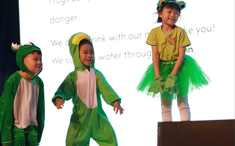  KS1 pupils combining creative learning, confident speaking, costumes, and dance in an exciting animal-themed assembly. 