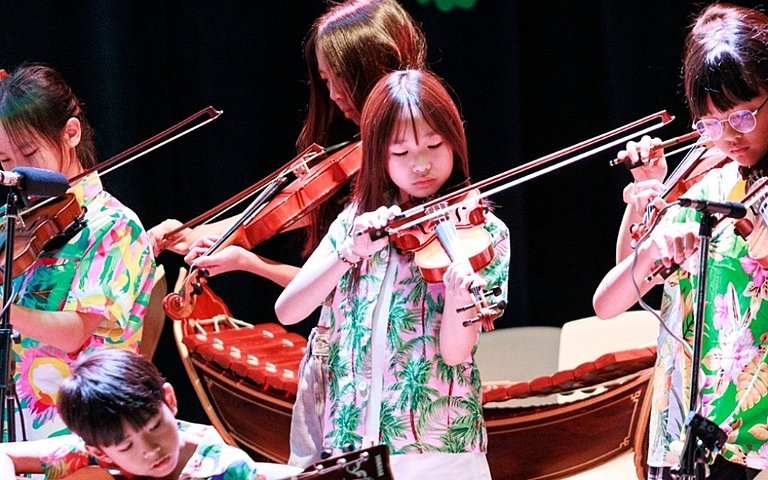  Pupils confidently performing on stage during Splash of Sound, combining music with Songkran celebrations. 