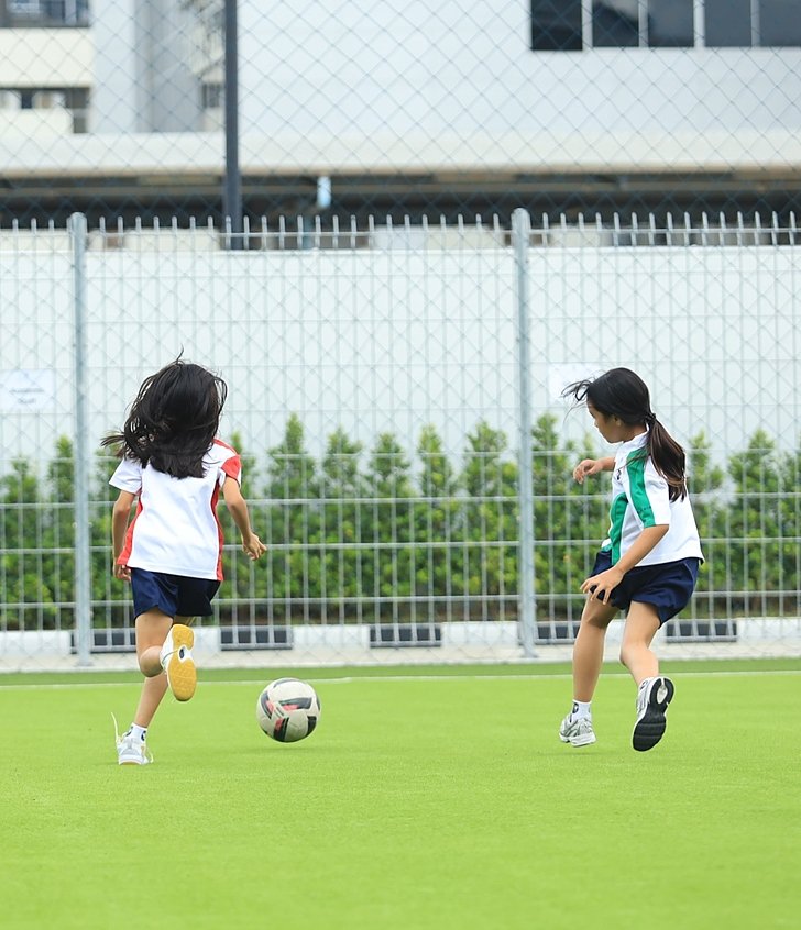  นักเรียนสองคนเล่นฟุตบอลอย่างสนุกสนานที่โรงเรียนอินเตอร์กรุงเทพ ไบรท์ตัน คอลเลจ วิภาวดี 