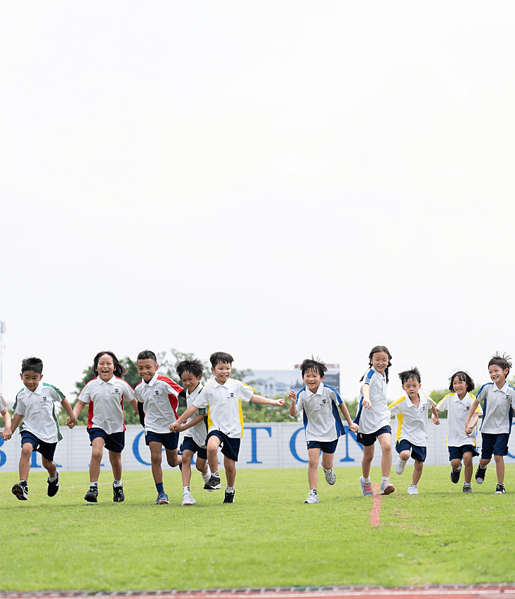  Brighton College Krungthep Kreetha pupils holding hands and running, showcasing friendship and joyful learning at top international school in Thailand. 